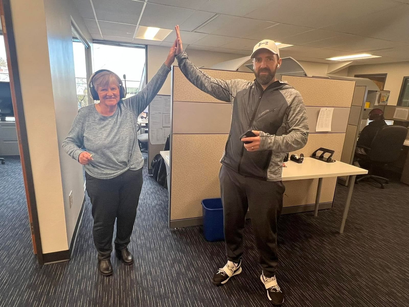 Two Senior Solutions colleagues high-five in the office